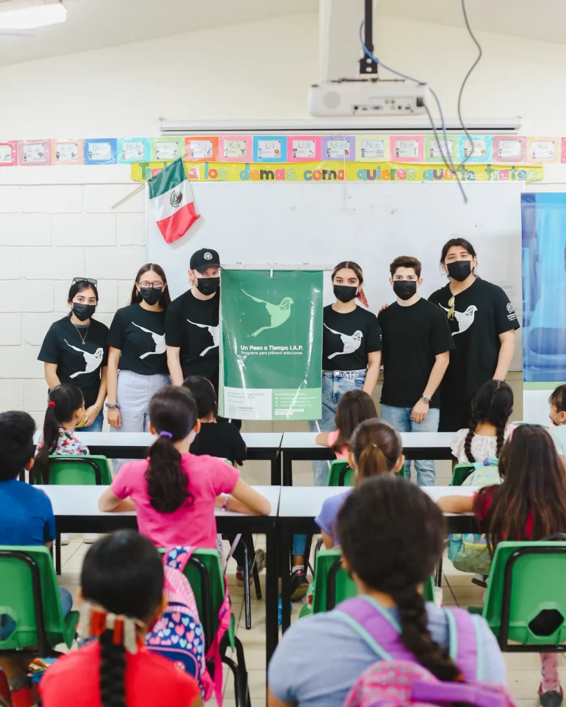 Voluntarios de Un Paso a Tiempo con niños en escuela